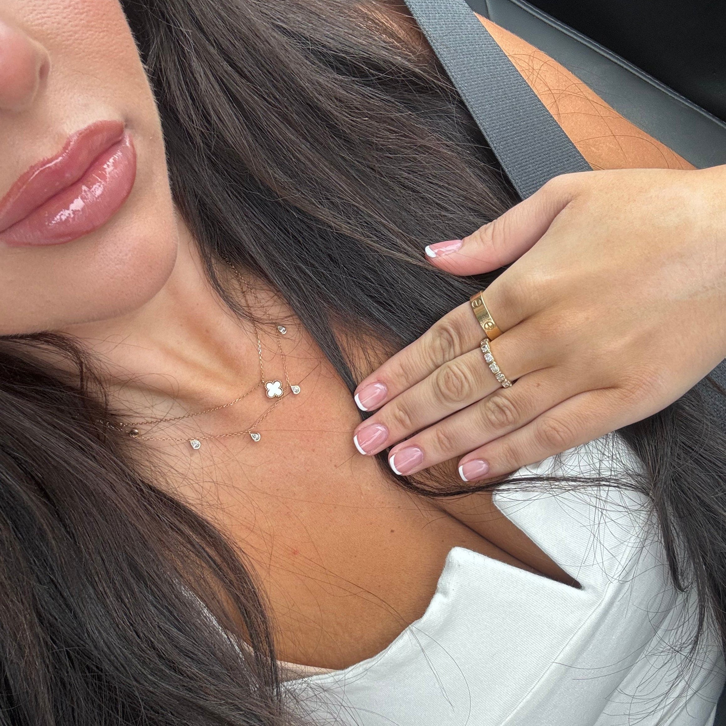 Model wearing the necklace layered with a Van Cleef necklace