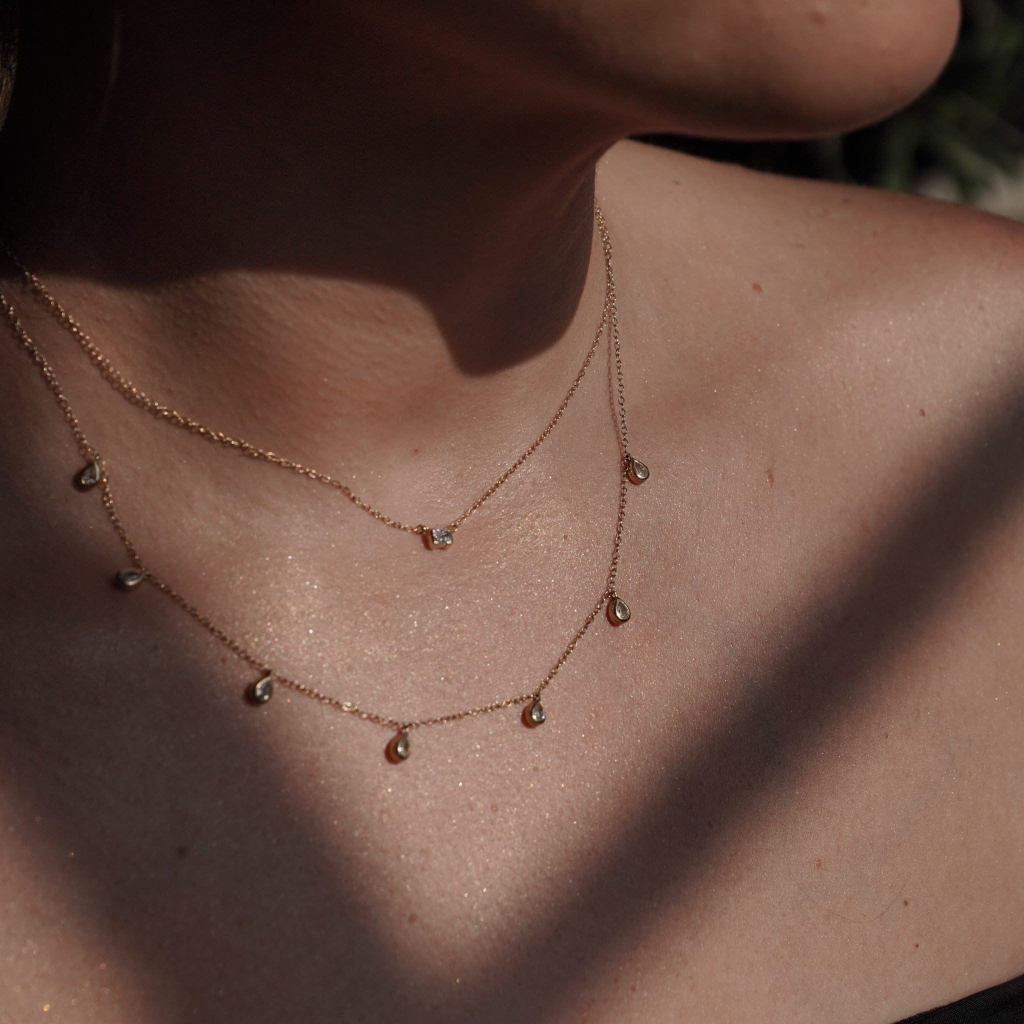 Model wearing the pendant layered with other SETTE pieces.