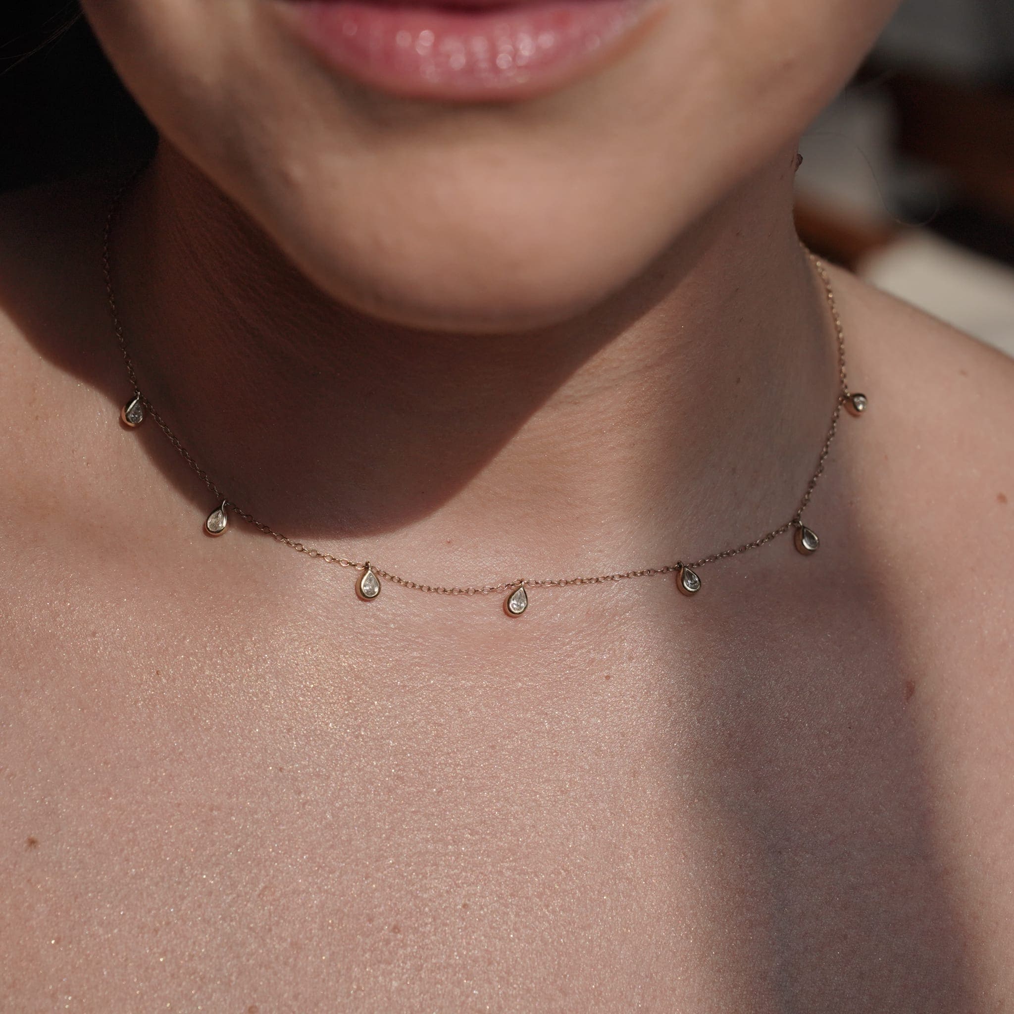 Model wearing the necklace layered with other SETTE pieces.