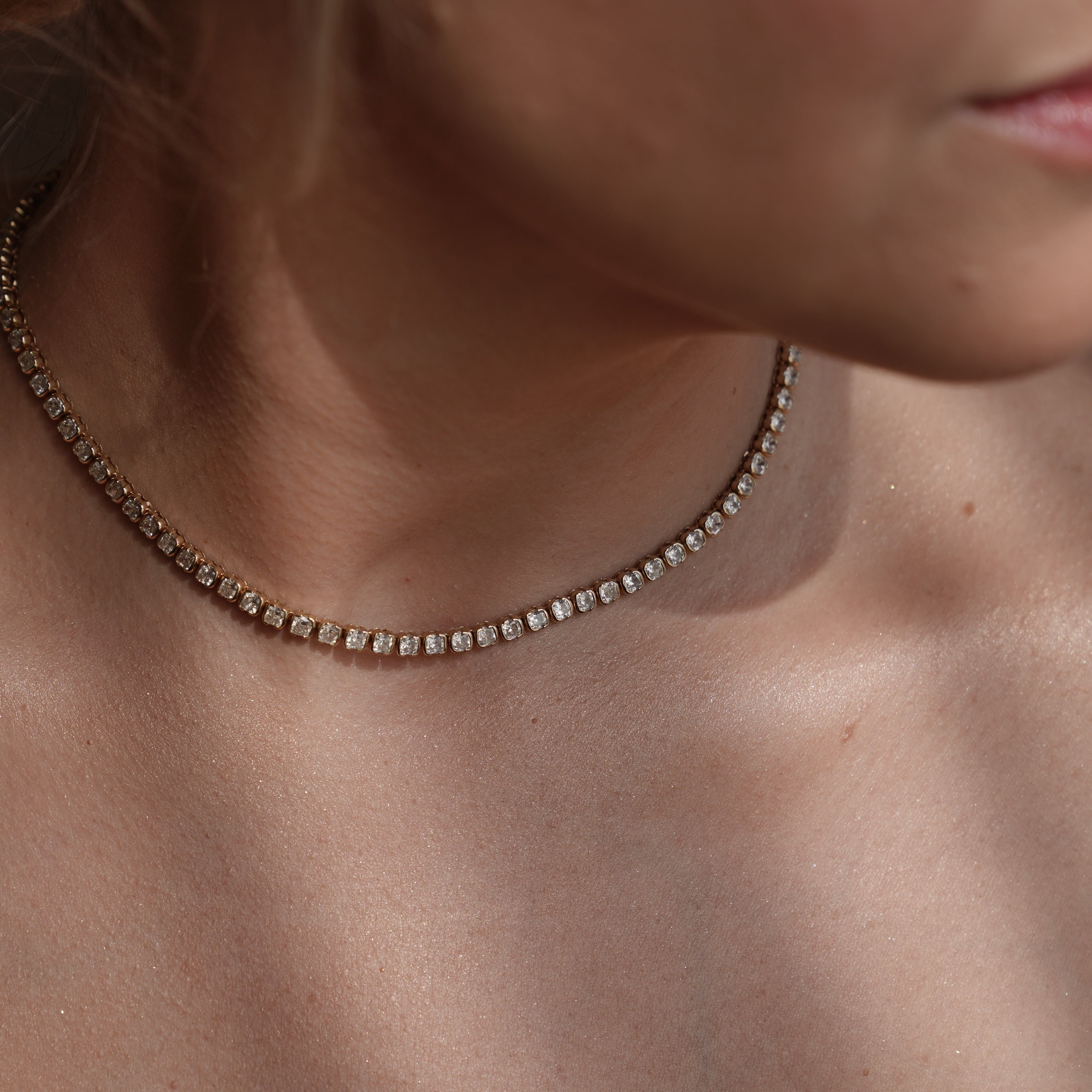 Model wearing the necklace layered with other SETTE pieces.

