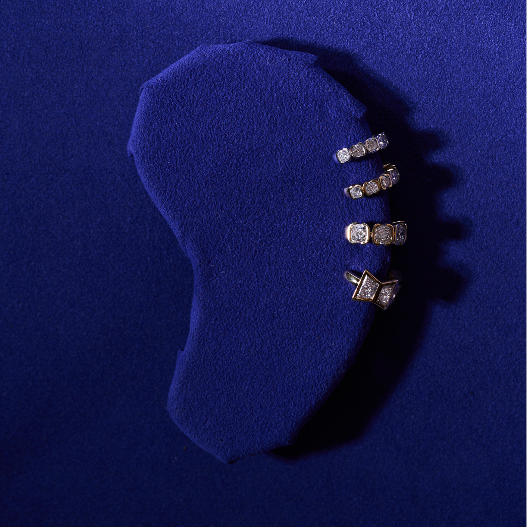 Trapezoid-cut lab diamond ear cuff displayed on a blue velvet stand.
