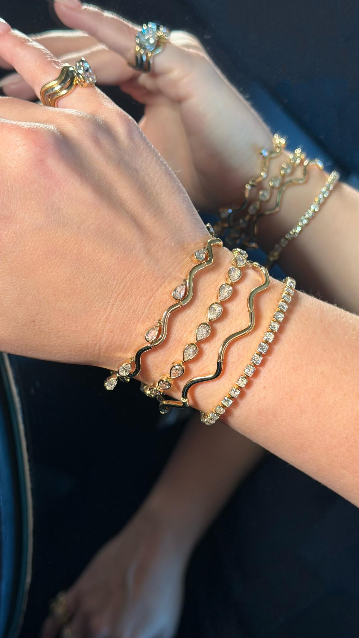 woman stacking bracelets and rings