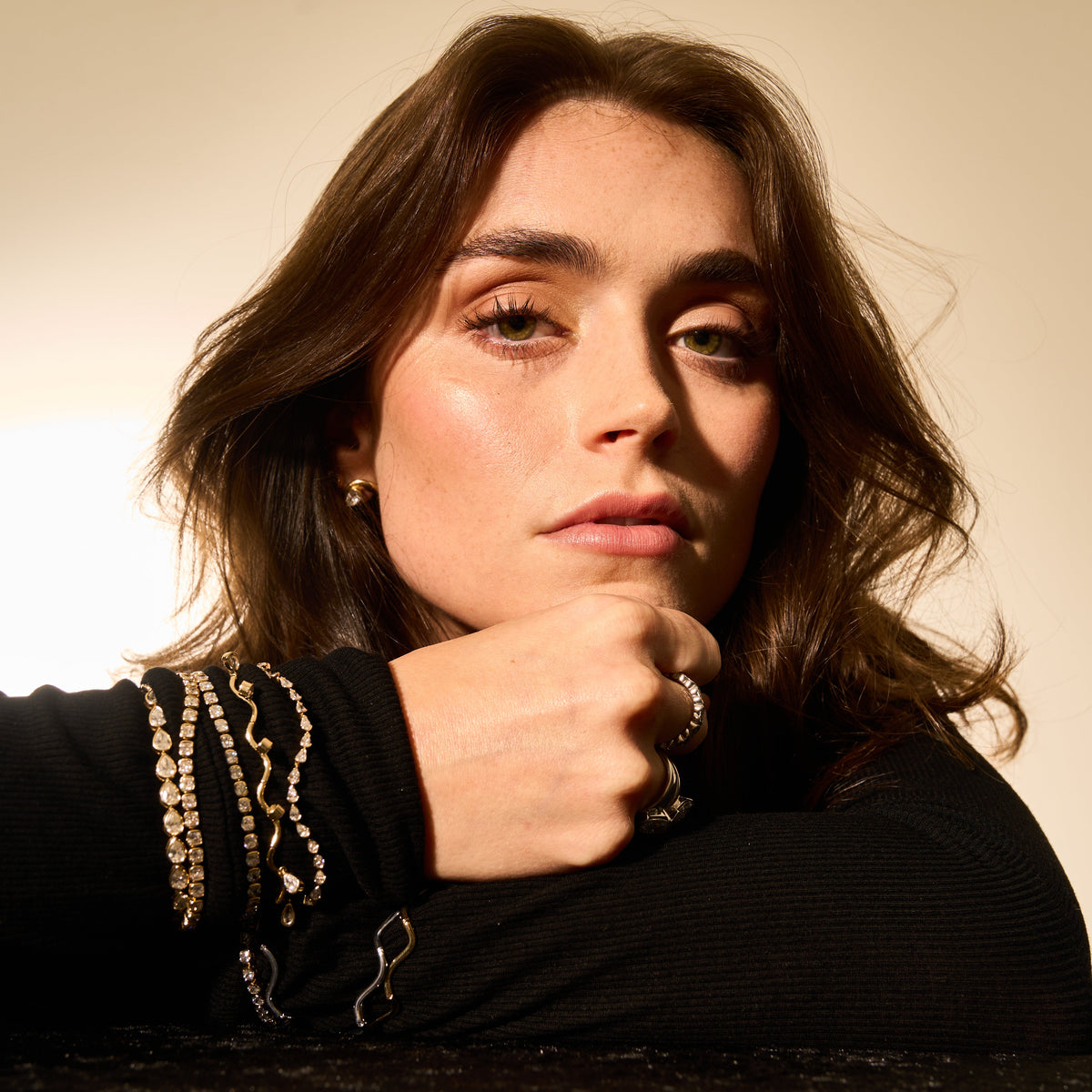 Woman with hand on chin against a neutral background
