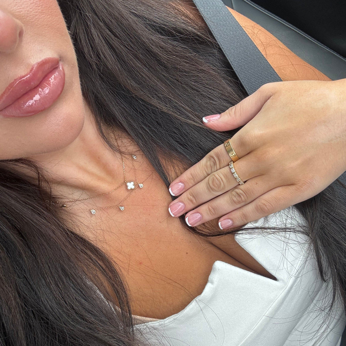 Model wearing the necklace layered with a Van Cleef necklace