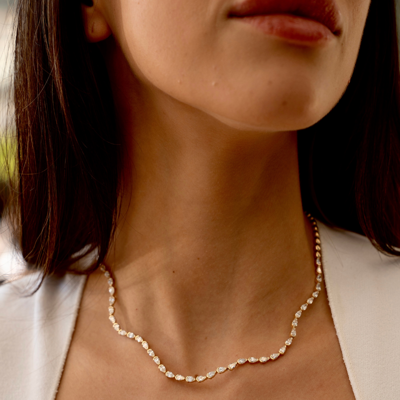 Model wearing the necklace layered with other SETTE pieces.


