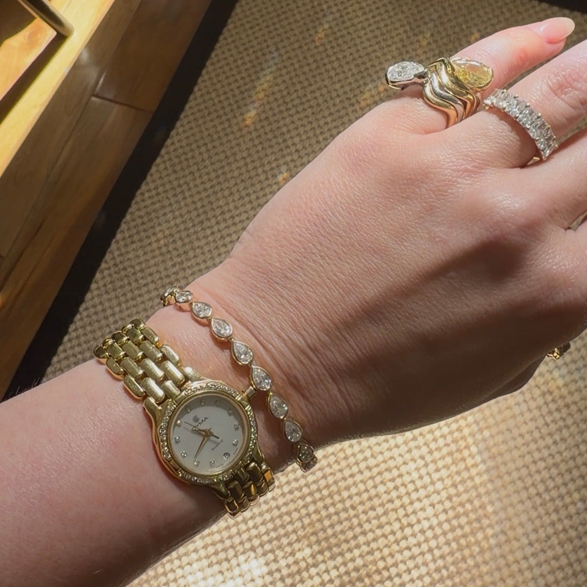 WOMAN STACKING HER BRACELET WITH AN 18K GOLD WATCH