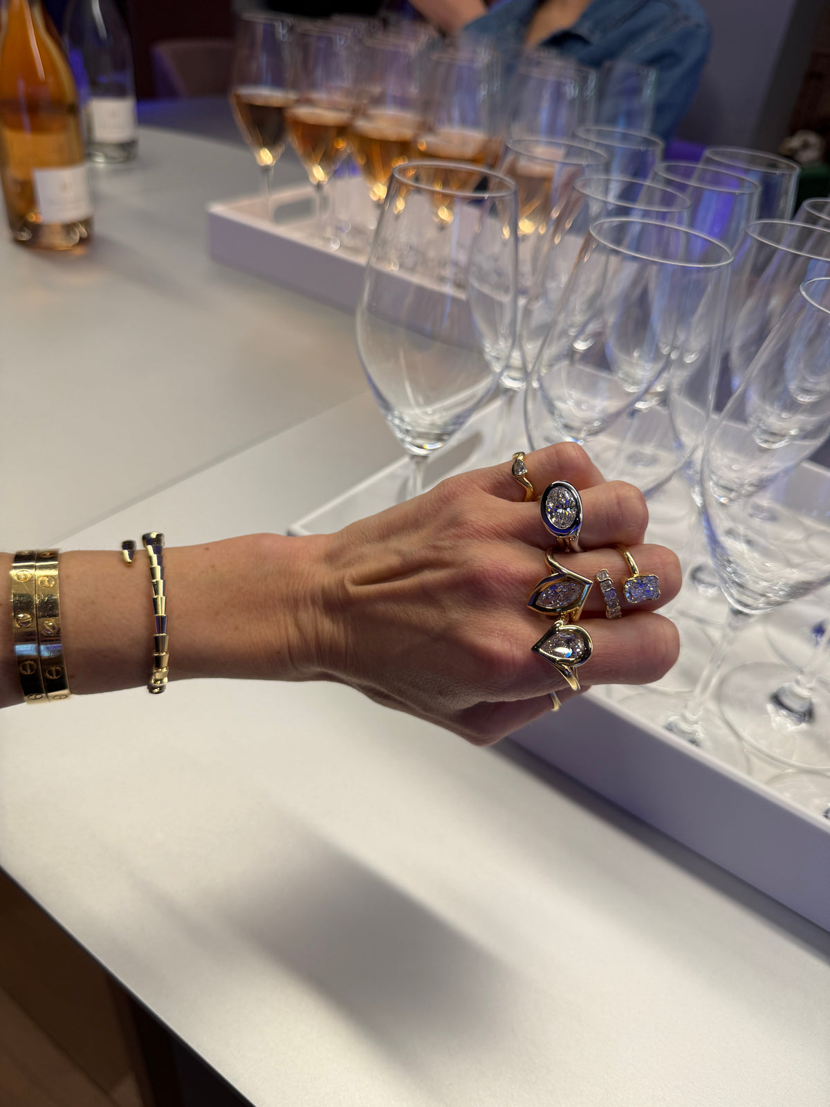 Woman wearing her dainty pinky ring next to her bold rings at a evening