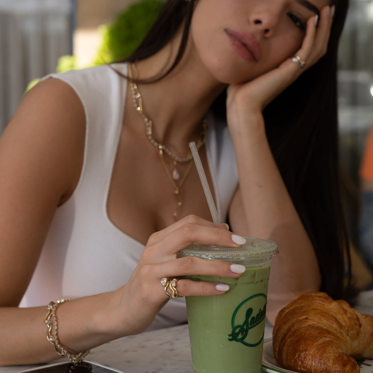 Girl drinking matcha with an iconic pinky ring stack