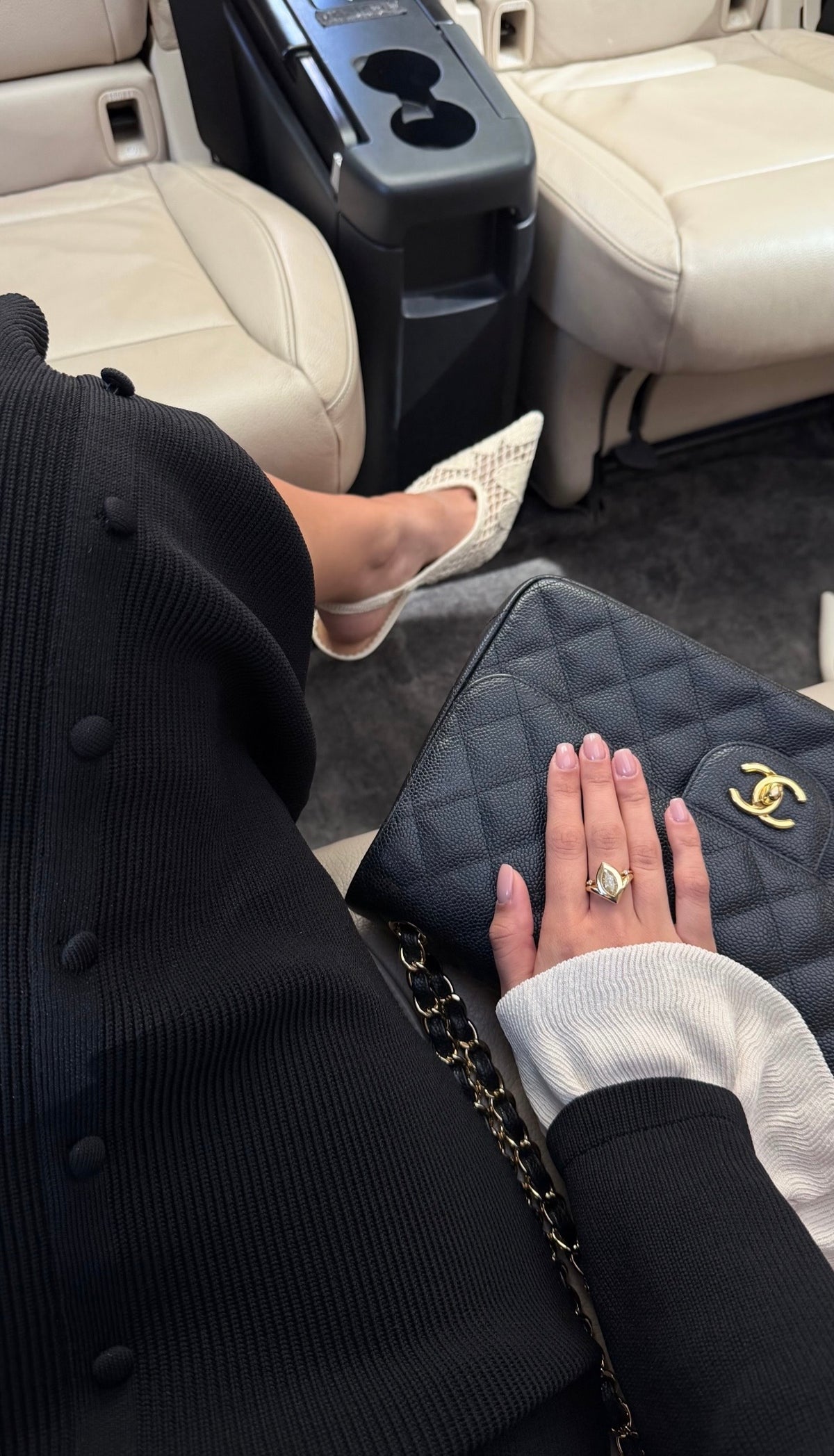 Woman wearing the Lueur Pear lab Diamond Ring on a private jet with her chanel purse