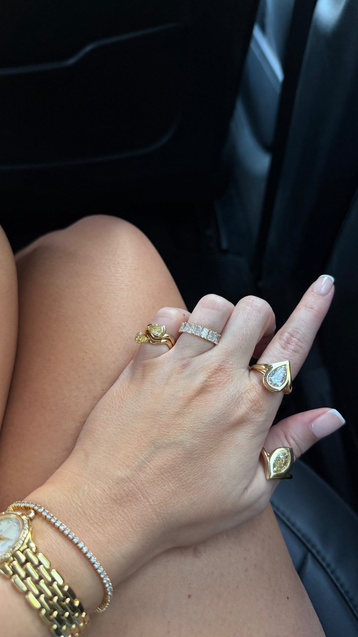 Woman in the back of an uber black with her full ring stack