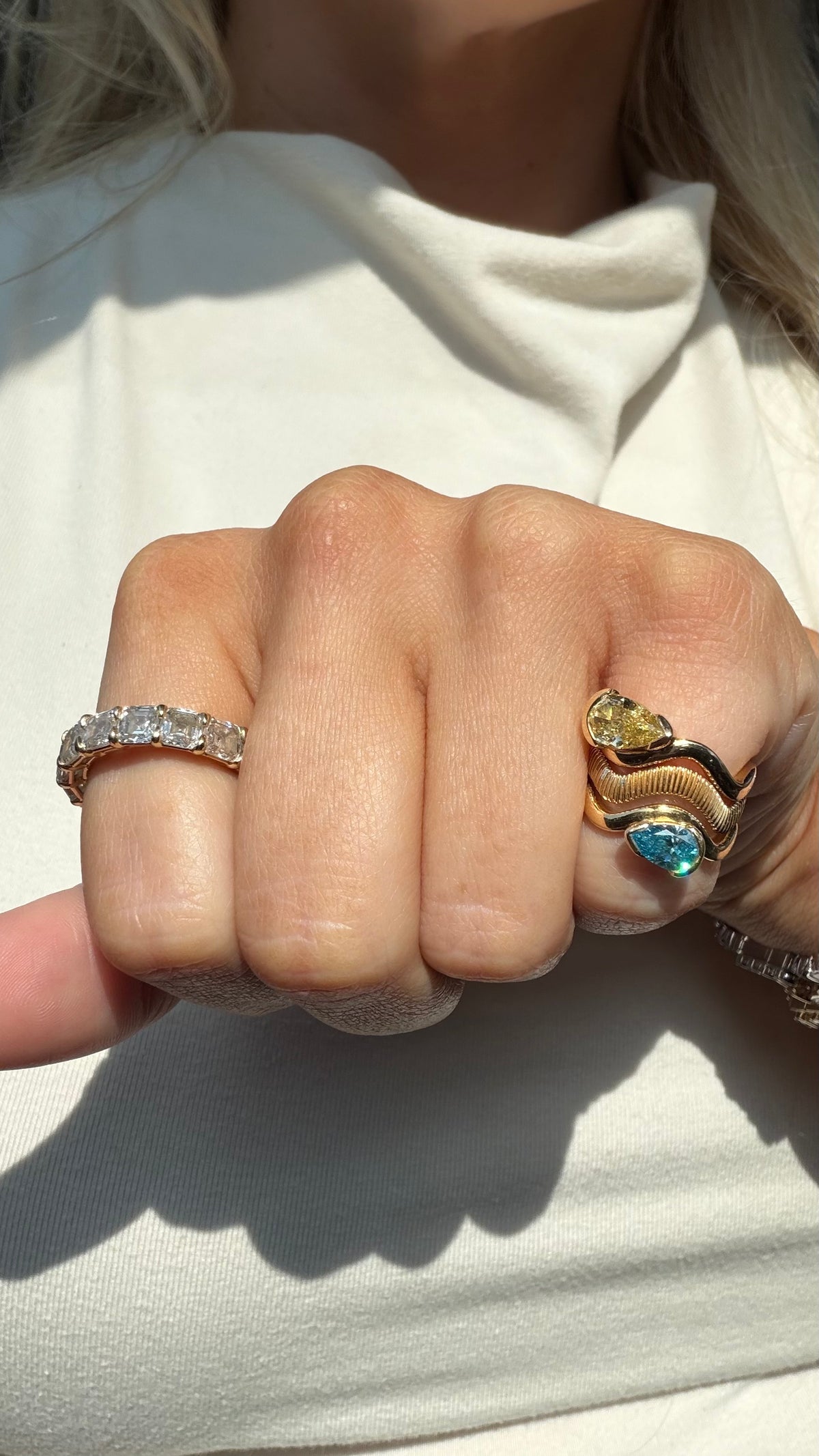 Woman embracing colored lab diamond pinky ring stack