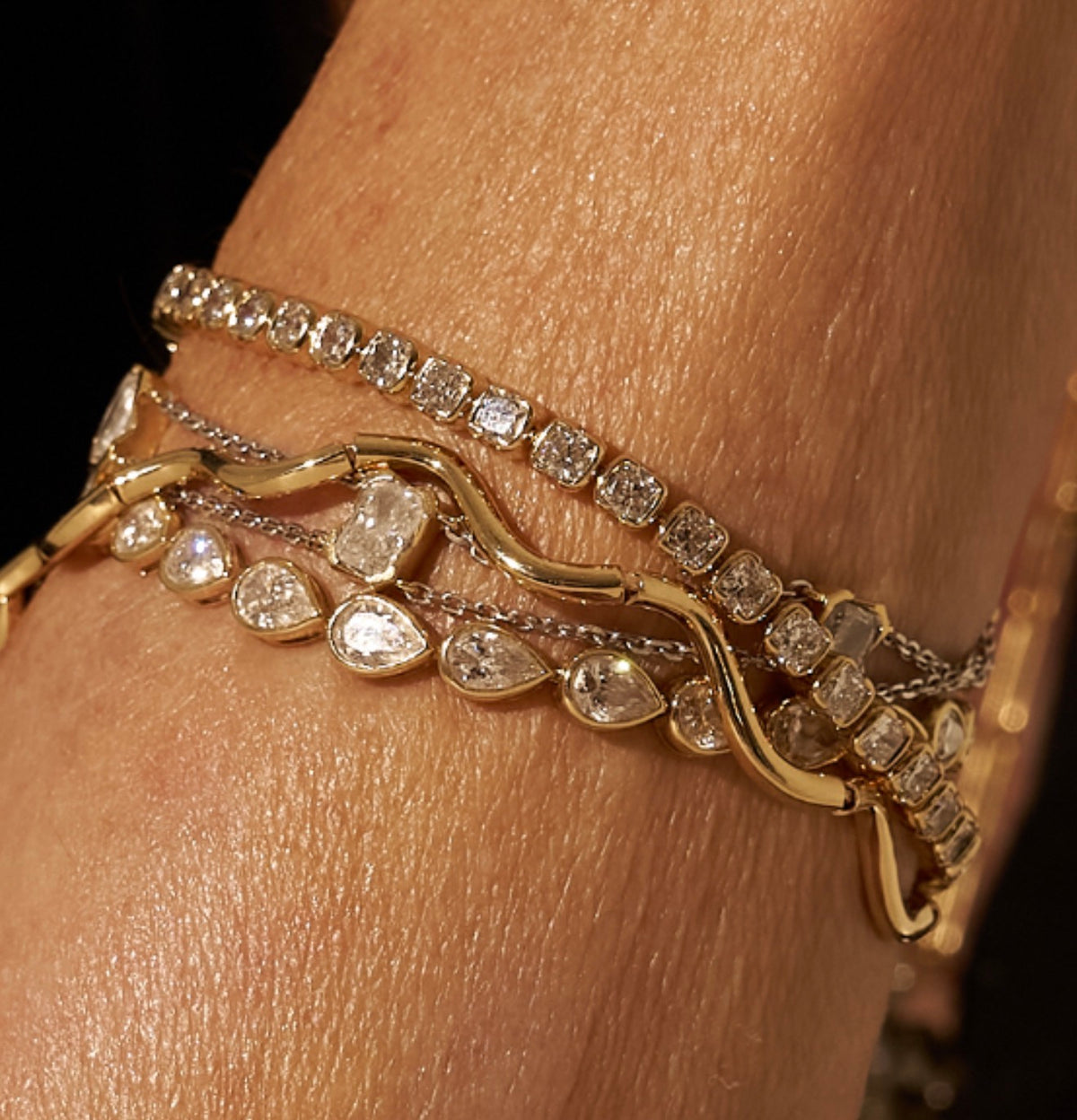 A woman wearing a stack of lab diamond tennis bracelets