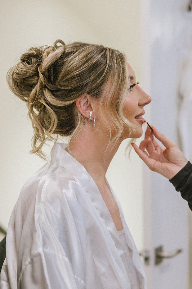 woman getting her hair done with the arc earring