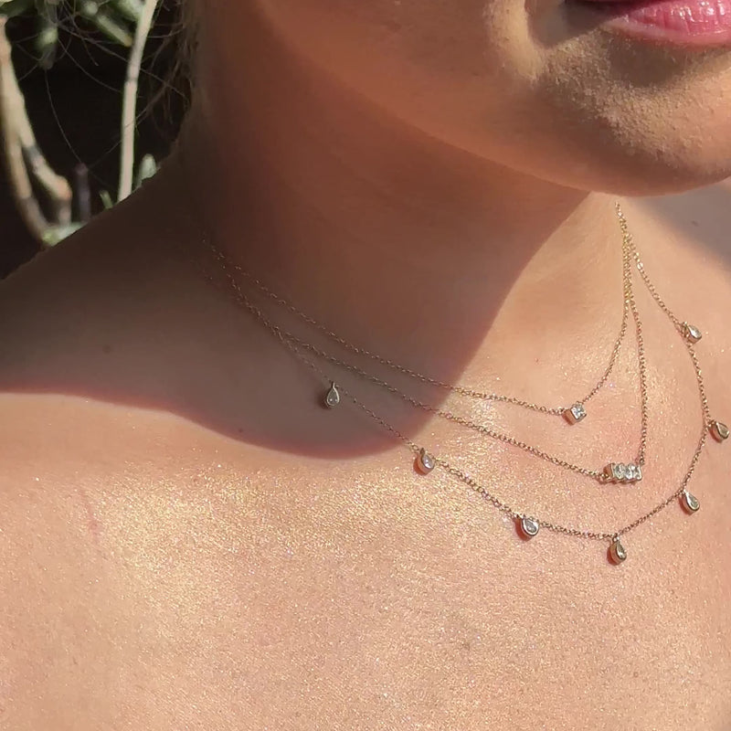 Model wearing the pendant layered with other SETTE pieces.

