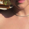 Model wearing the necklace layered with other SETTE pieces.