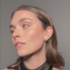 Model wearing a 14K yellow gold ear cuff with cushion-cut lab diamonds from SETTE Jewelry.
