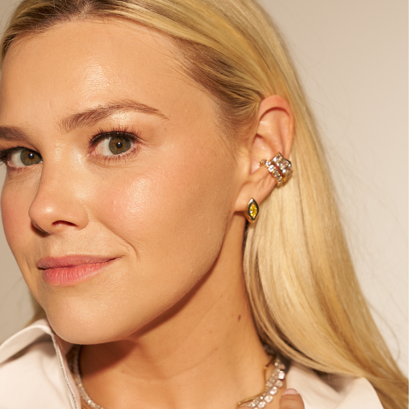 Blonde model wearing the SETTE Lueur Huggie marquise lab diamond earrings in 14K gold